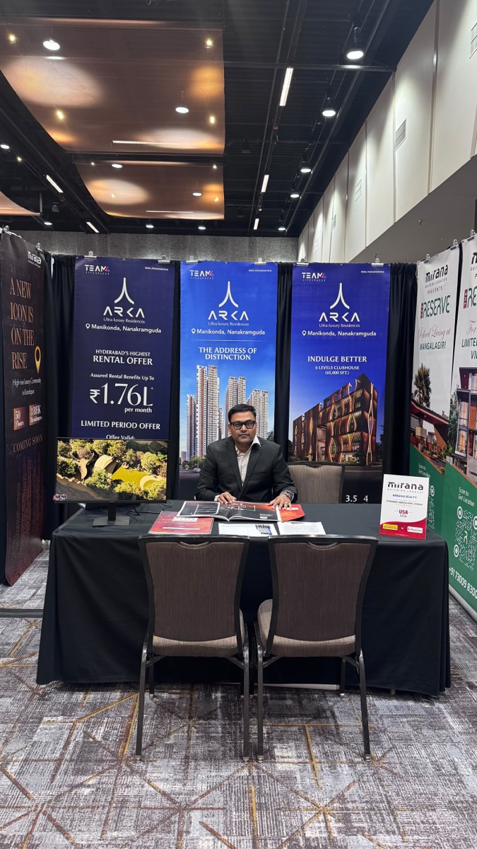 Ravi Kiran seated with property brochures and project displays